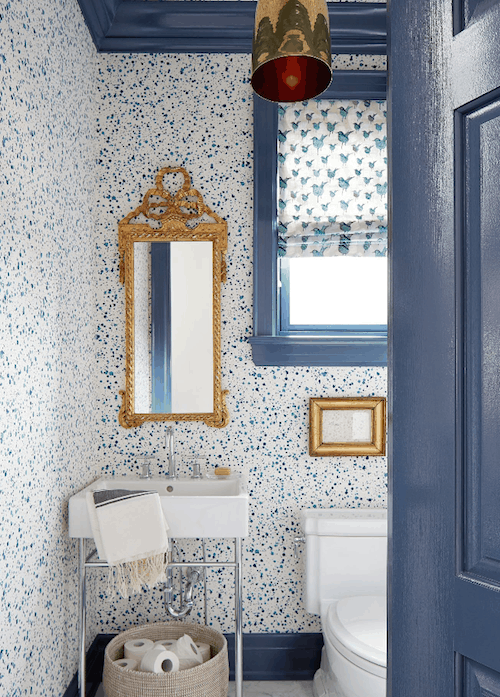 bathroom with blue door and speckled wallpaper