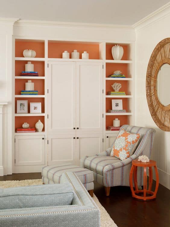 built-in bookshelves with a painted orange backdrop