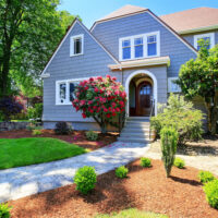 American craftsman house exterior. View of entry door and porch with concrete stairs. Nice landscape design around. Northwest, USA